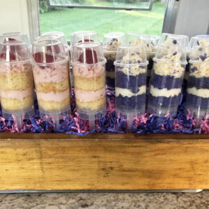 Group of strawberry cake push pops and purple cake push pops
