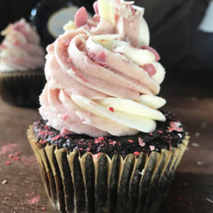 Chocolate cupcake with pink and white frosting and pink sprinkles