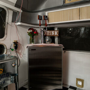 Kegerator fridge with two taps inside of Airstream mobile bar